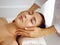 Beautiful brunette woman enjoying facial massage with closed eyes. Relaxing treatment in medicine and spa center