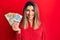 Beautiful brunette woman holding australian dollars with a happy and cool smile on face