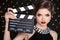 Beautiful brunette woman model holding film clap board cinema