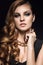 Beautiful brunette woman with perfect skin, bright makeup and gold jewelry. Beauty face.