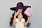 Beautiful Brunette Woman with pink gift box wearing wide purple broad brim hat