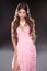 Beautiful brunette woman posing in pink gorgeous dress isolated