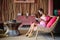 Beautiful brunette woman sitting on a pink couch and reading a book and smiling. Interior in ethnic style