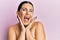Beautiful brunette woman standing topless wearing face cream smiling and laughing hard out loud because funny crazy joke