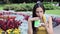 Beautiful brunette woman waiting in the park drink coffee play in smartphone call phone smile flower summer good weather chec