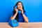 Beautiful brunette young woman speaking on vintage telephone serious face thinking about question with hand on chin, thoughtful