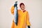 Beautiful brunettte fisher woman wearing raincoat holding fresh salmon looking positive and happy standing and smiling with a