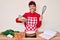 Beautiful brunettte woman cooking carrot cake using whisk sticking tongue out happy with funny expression