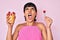 Beautiful brunettte woman eating fresh and healthy fruit angry and mad screaming frustrated and furious, shouting with anger