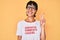 Beautiful brunettte woman wearing sarcastic comments loading t-shirt smiling with happy face winking at the camera doing victory