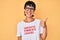 Beautiful brunettte woman wearing sarcastic comments loading t-shirt smiling happy and positive, thumb up doing excellent and