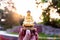 Beautiful Buddha idol held with the fingers and bright sunrise in the background creating colorful bokeh