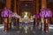 Beautiful buddhist wooden temple interior with Buddha statue and orchids flowers at Wat Bandensali in Thailand