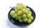 Beautiful a bunch of Shine Muscat green grape on a blue plate isolated on white background