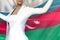 Beautiful business lady holds Azerbaijan flag in hands behind her back on the office building background - flag concept 3d