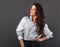 Beautiful business smiling woman with long brown healthy hair style looking up and presentation something in white shirt. Healthy