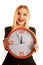 Beautiful business woman holds a clock as a sign for time manage