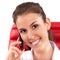 Beautiful business woman talking on mobile phone sitting on a red chair in office