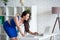 Beautiful businesswoman designer in blue dress looks into the laptop. Female business in the office