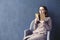 Beautiful businesswoman sitting in loft office reading vintage book. Opened book brown cover. Dark blue wall background, day light