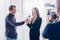 Beautiful businesswoman in suit giving interview to journalist, holding microphone and looking at camera