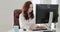 Beautiful businesswoman working in office looking at computer monitor