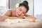 Beautiful, calm Asian woman lying on massage table with eyes closed in beauty spa salon