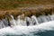 Beautiful calm clear river water waterfall with visible rocks and pure white foam