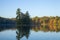 Beautiful calm lake with trees in autumn color and a small island in northern Minnesota at dawn