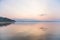 A beautiful, calm morning landscape of lake and mountains in the distance. Colorful summer scenery with mountain lake in dawn.