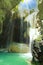 Beautiful caribbean jungle cave with waterfall, sun rays, natural water pool  - Somerset waterfalls, Portland, Jamaica focus on