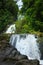 Beautiful cascade waterfall hidden in a forest. Adventure and travel concept. Nature background. Kaiate Falls, Bay of