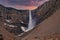 Beautiful cascades of Hengifoss falling from mountains against dramatic sky