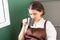 Beautiful caucasian barista woman sits near window and drinks hot coffee in breaking time at coffee shop