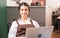 Beautiful caucasian barista woman sits relaxing and using laptop in breaking time at coffee shop