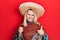 Beautiful caucasian blonde woman wearing festive mexican poncho drinking tequila shot smiling happy and positive, thumb up doing