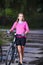 Beautiful Caucasian Female Biker with Mountain Bike Walking On S