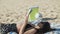 Beautiful Caucasian girl lying on back on beach and reading book