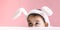 Beautiful caucasian girl peeking and looking to the side with headband easter bunny ears