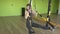 Beautiful caucasian girl professional trainer performs difficult exercises on the hinges TRX