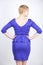 Beautiful caucasian girl with short hair and plus size body dressed in blue medium length dress in business style with peplum at t