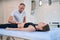 Beautiful Caucasian lady on massage table getting physiotherapy session in wellness center
