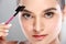Beautiful caucasian model using an eyebrow brush