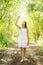 Beautiful caucasian preteen girl wearing flower wreath and white dress in forest. Fairy background