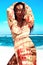 Beautiful caucasian sunbathed woman model with dark long hair posing on summer beach