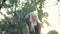 Beautiful caucasian teen girl fashion model walks and whirls in nature, straightens long blonde hair. Young aesthetic
