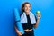 Beautiful caucasian teenager girl holding yoga mat and green apple smiling looking to the side and staring away thinking