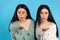 Beautiful caucasian twin girls blow a kiss to the camera. Blue background