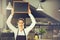 Beautiful Caucasian woman in barista apron holding empty blackboard sign inside coffee shop