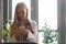 Beautiful caucasian woman with blond hair white skin using smartphones at the windows side in office